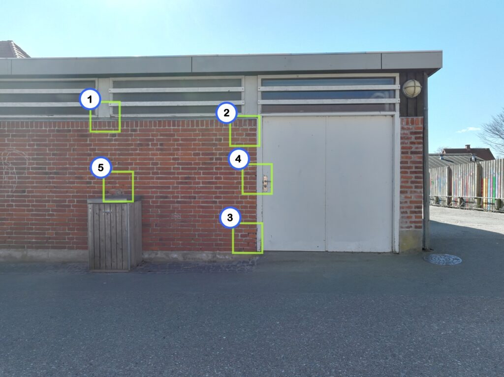 Facade på boligblok dokumenteret med drone, hvor fund er markeret på billedet